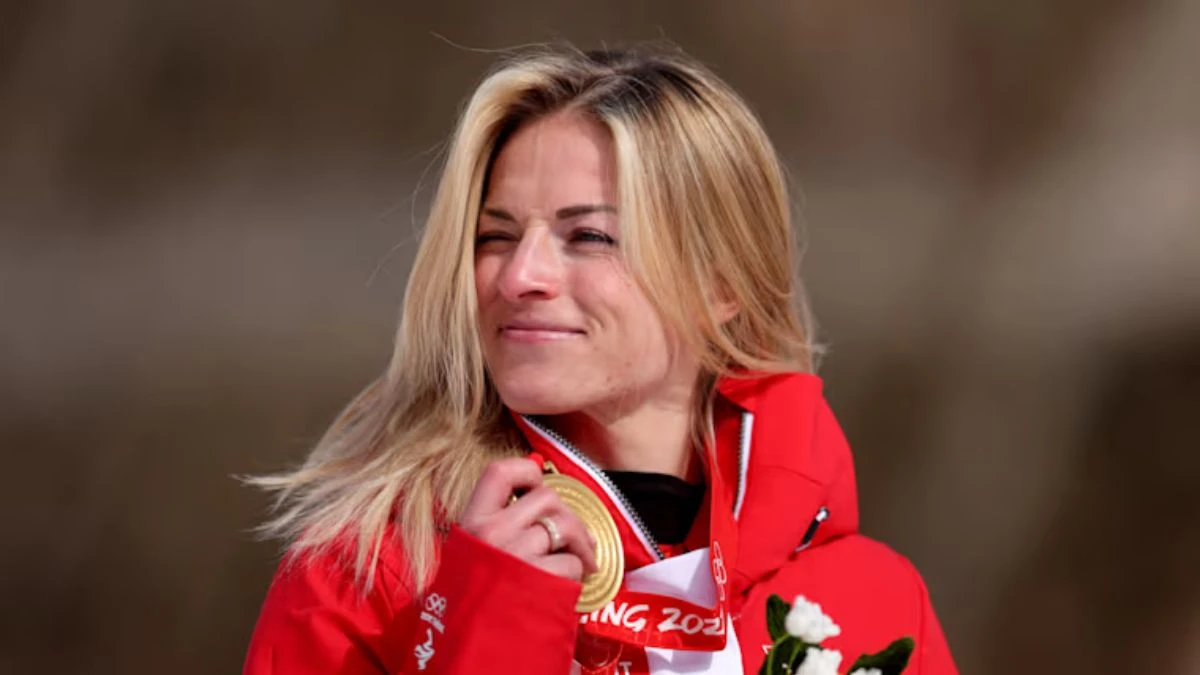 Primo piano di Lara Gut-Behrami con sguardo determinato, casco e tuta da sci