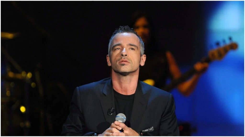 Eros Ramazzotti con microfono in mano durante un concerto